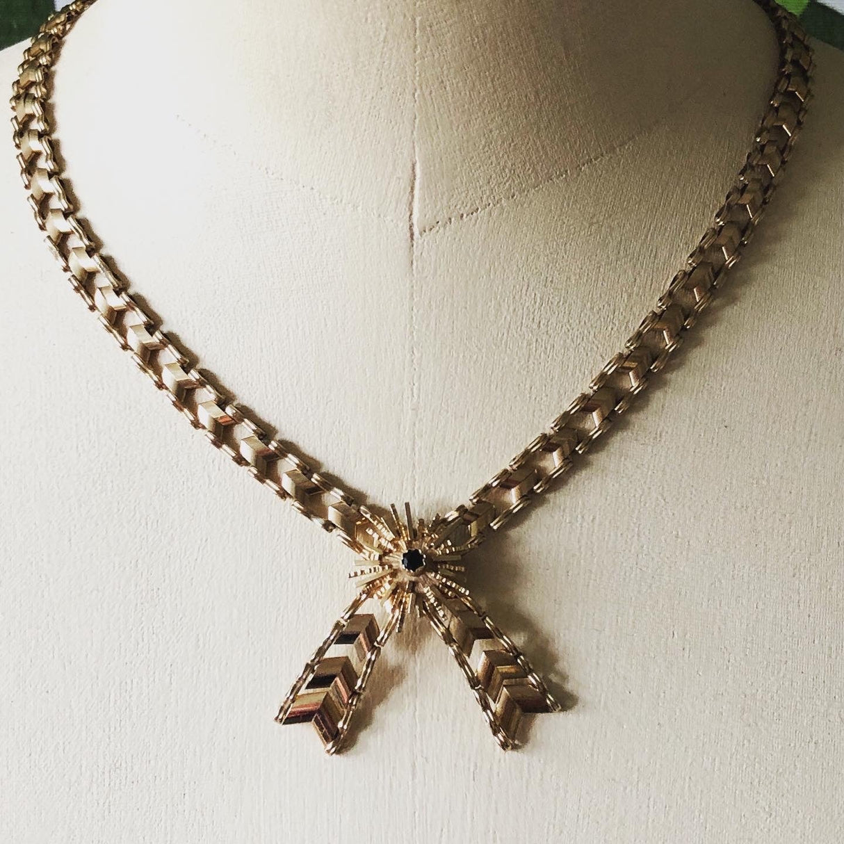 1970s 9k Gold Necklace with a Tied Ribbon Design Set with a Sapphire The Vintage Jewellery Company