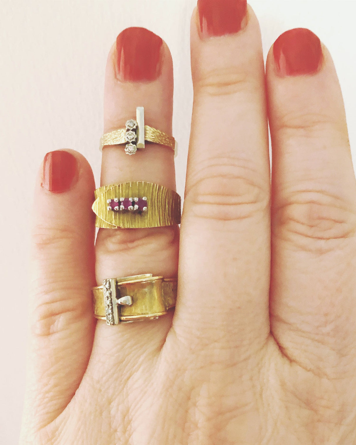 Vintage gold wrapover belt ring with engraved detail and set with three rubies The Vintage Jewellery Company